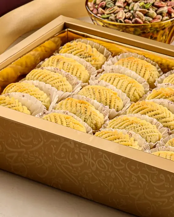 Rows of semolina maamoul, each pressed with a carved pattern.
